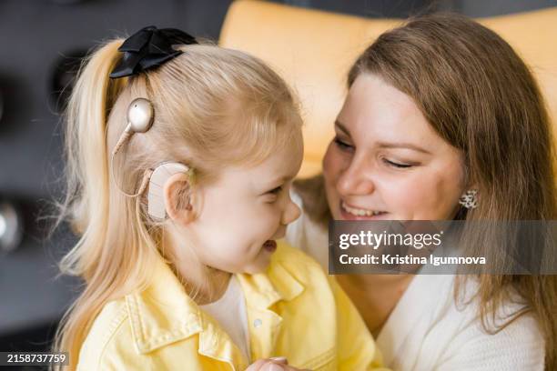 A child with a cochlear implant spends time with his mother at home.